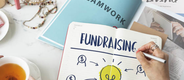 Notebook illustrating a nonprofit fundraising strategy with financial planning concepts for sustainable fundraising success.