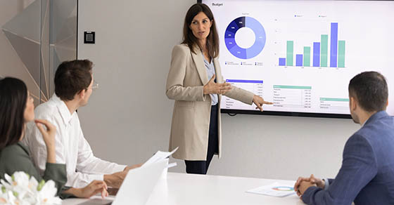 Woman business professional reviewing financial reports during a board presentation with an accounting firm in Howard County.