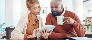 Couple reviewing financial information on a tablet while planning for retirement with expert tax preparation in Baltimore County.