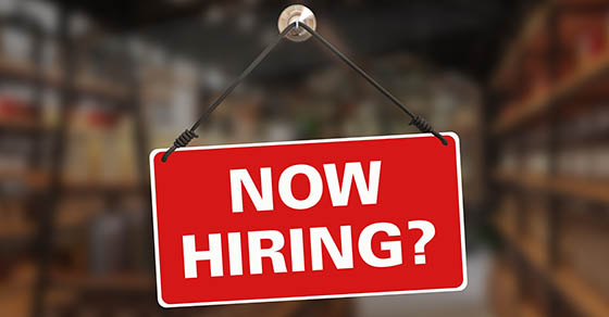 Red "Now Hiring?" sign hanging in a shop window, representing nonprofit hiring decisions and budgeting guidance from an accountant in Columbia, MD at Weyrich, Cronin & Sorra.