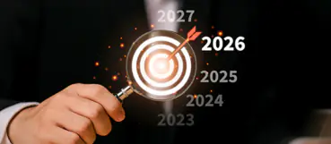Hand holding a magnifying glass over a target with 2026 highlighted, representing year-end tax planning by Weyrich, Cronin & Sorra