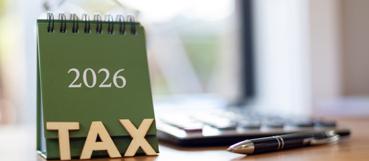 Green 2026 tax desk calendar next to a calculator and pen, representing year-end tax planning from Weyrich, Cronin & Sorra