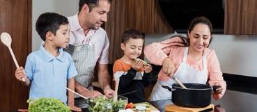 Parents and two young children cooking together in a kitchen, illustrating Trump Accounts guidance from Weyrich, Cronin & Sorra