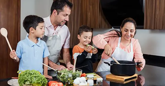Parents and two young children cooking together in a kitchen, illustrating Trump Accounts guidance from Weyrich, Cronin & Sorra